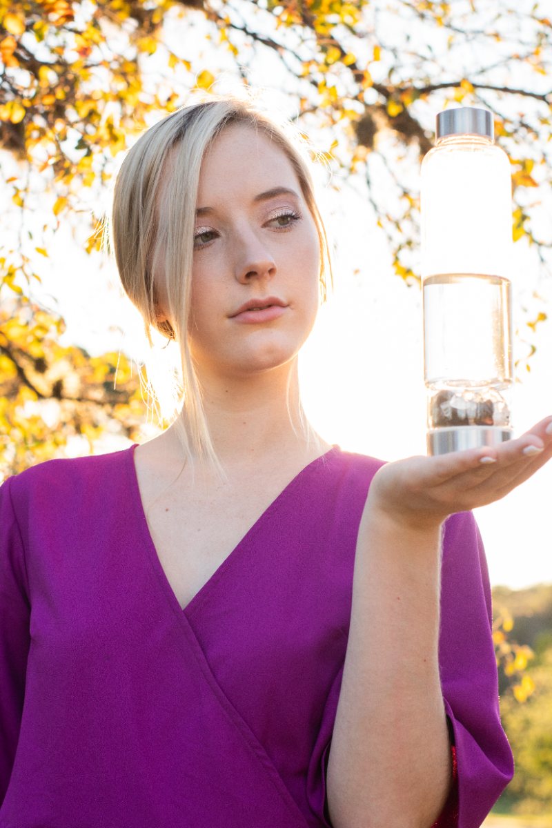 The Elixir2Go held in golden light, gemstones visible in the lower chamber